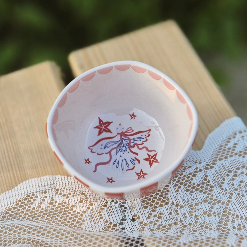 Detailfoto van het kleurrijke schaaltje, rood met wit en strikillustratie van all the luck in the world