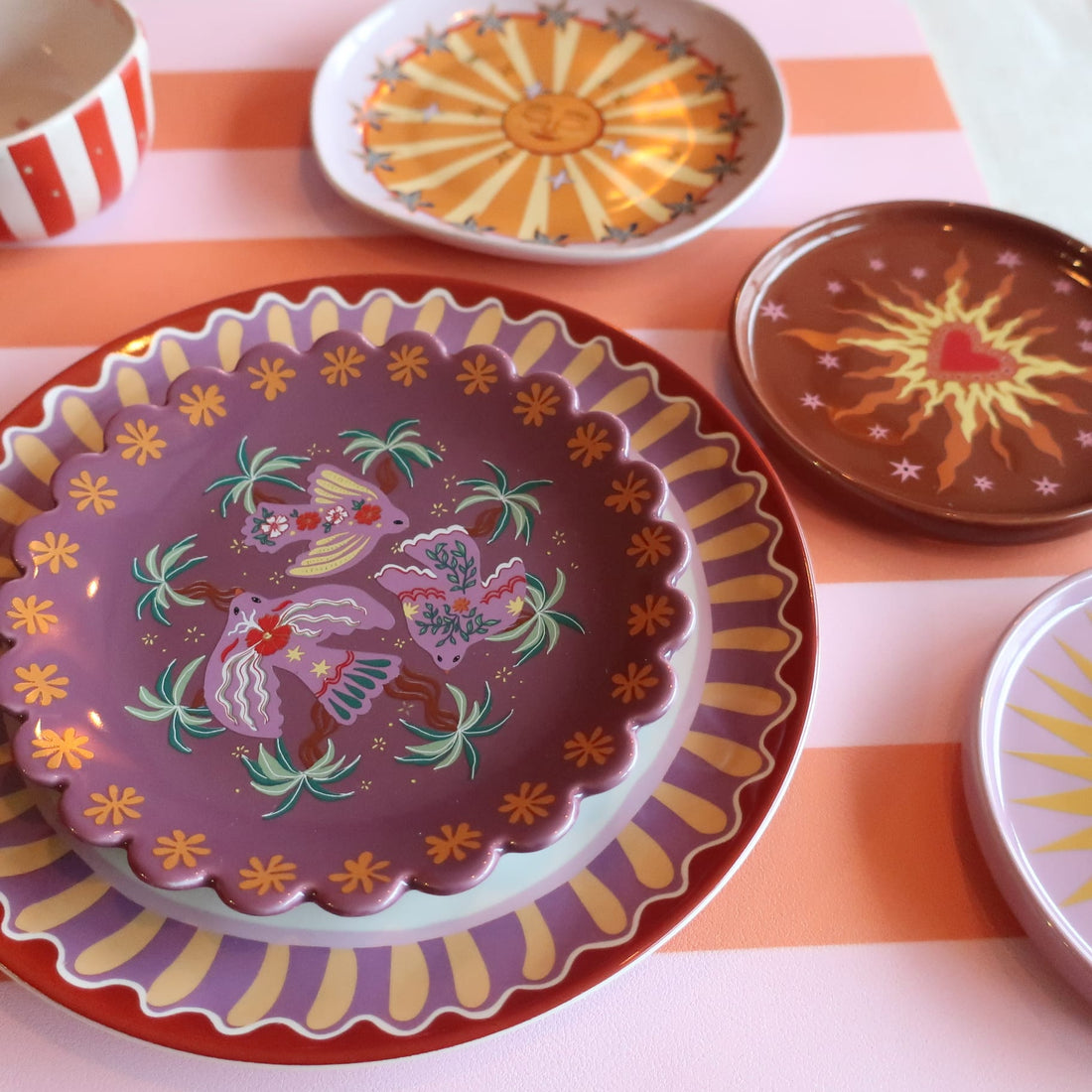 Servies van All the Luck in the World op een tafel, mix van kleuren en prints