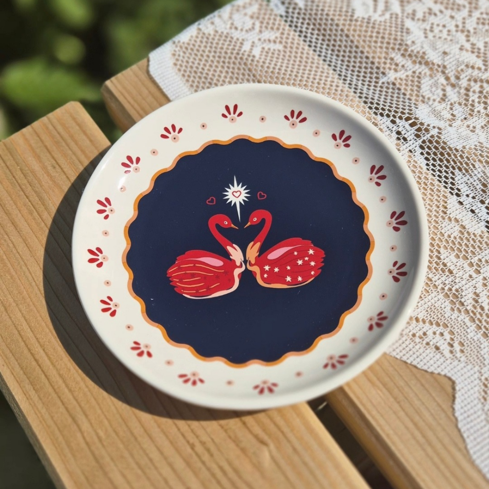 Detailfoto van kleurrijk bordje met zwanen van All the Luck in the World