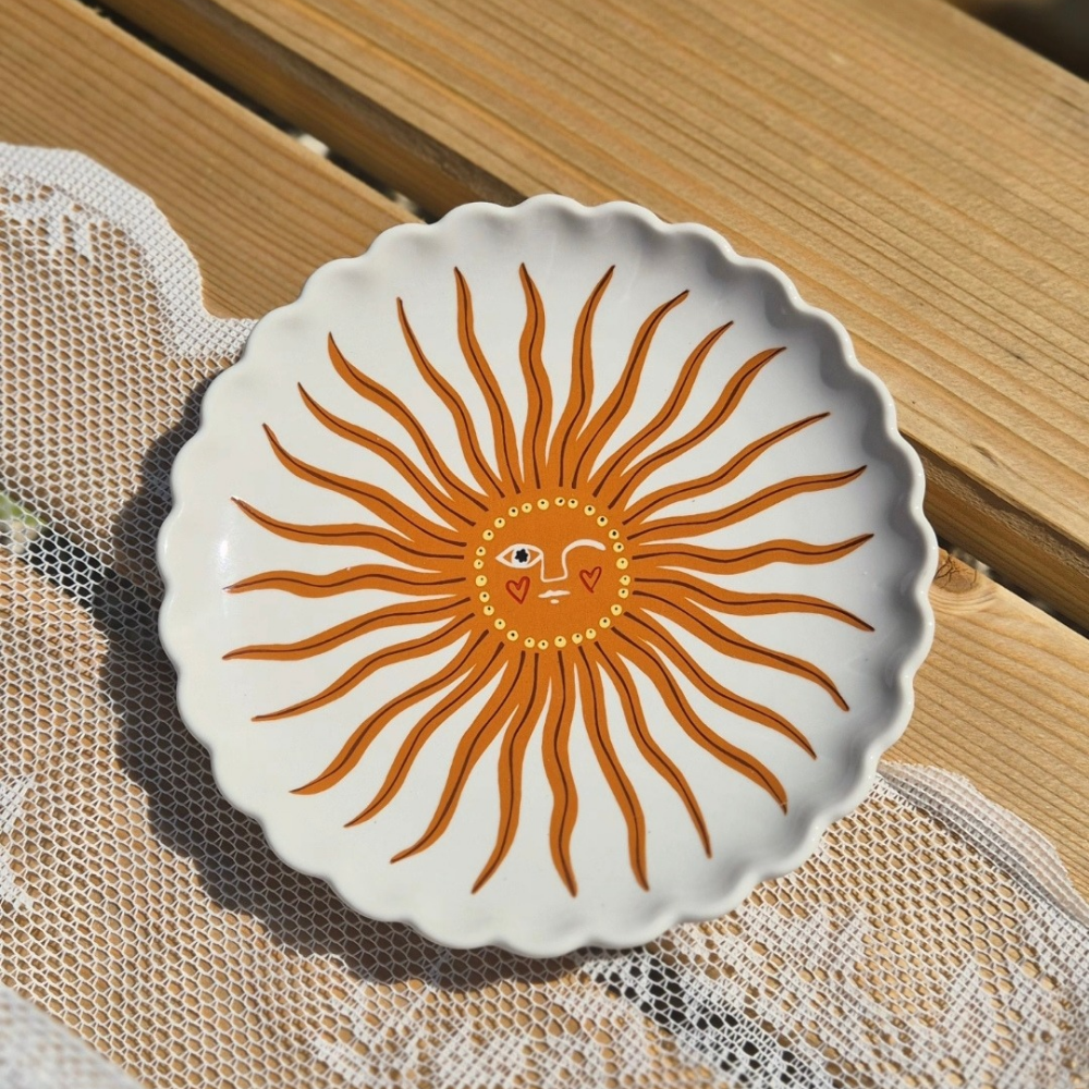 Detailfoto van het bordje zon van all the luck in the world. Wit met oranje zon 