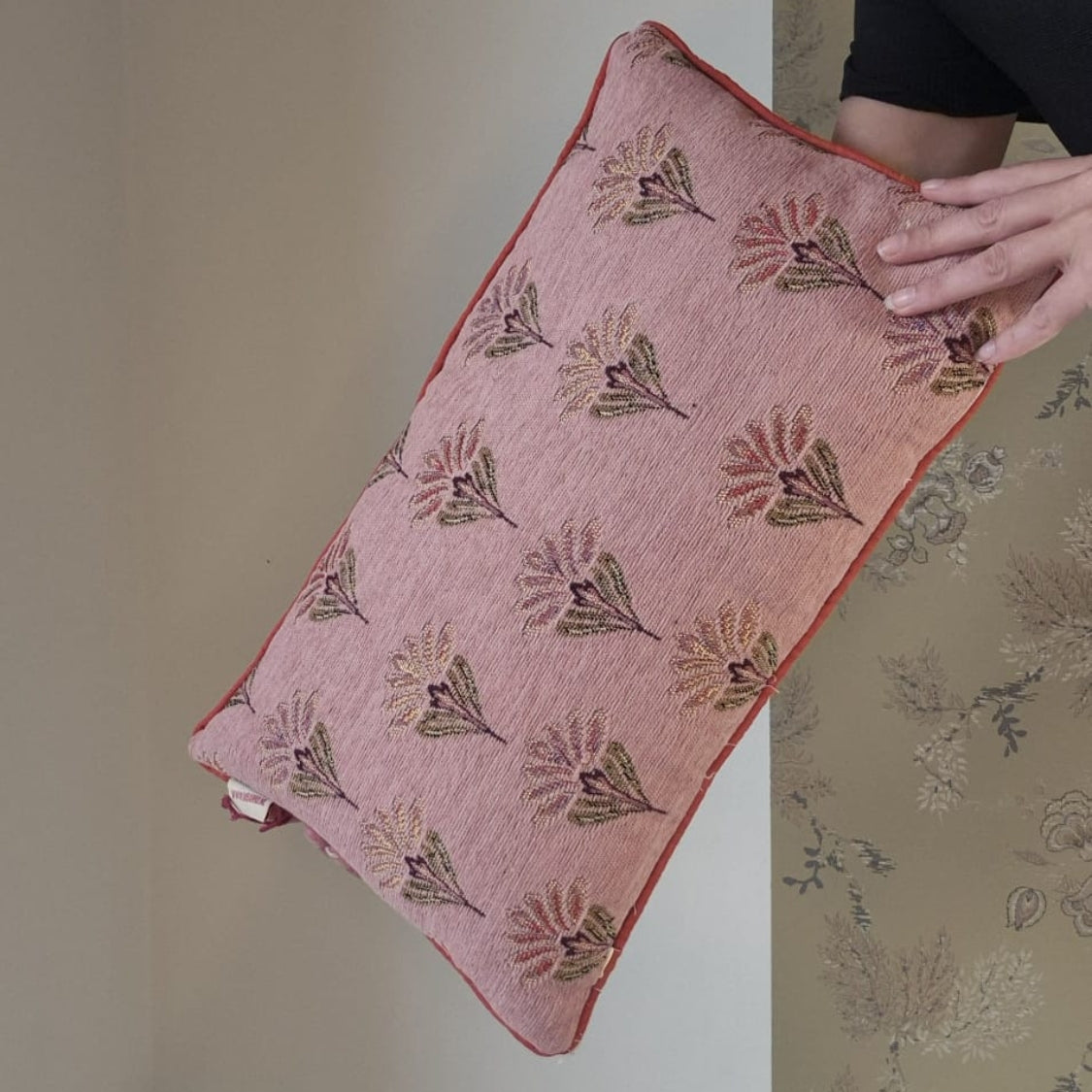 De ene kant van het sierkussen heeft mooie geborduurde bloemen. Een rustige print in een oud roze kleur.