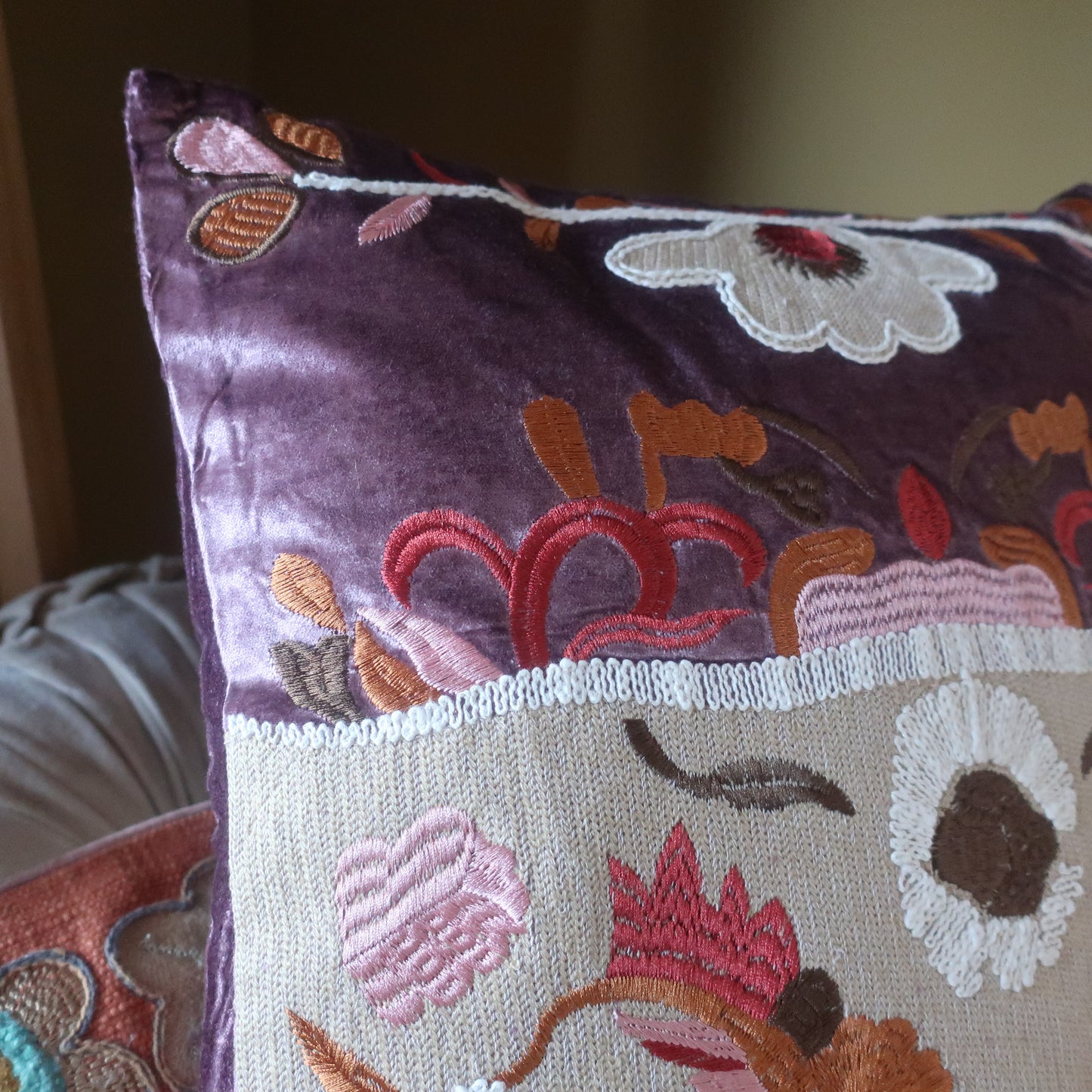 Close-up van het borduurwerk op handgemaakt velvet kussen Blossom van Imbarro met bloemen en ruitvormen.